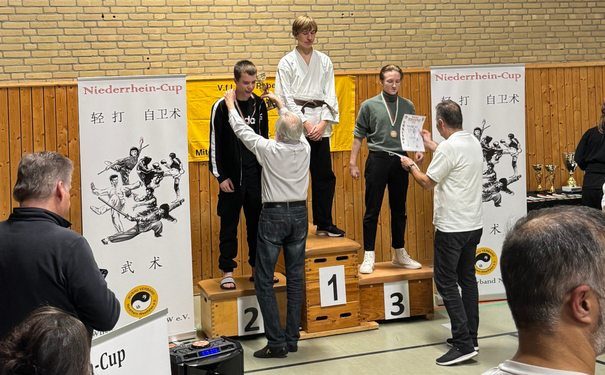 Die drei Sieger der U15 im Semi-Kontakt-Kickboxen im NRC. Roland Czerni verleiht die Medallie und Michael Mende die Urkunde.